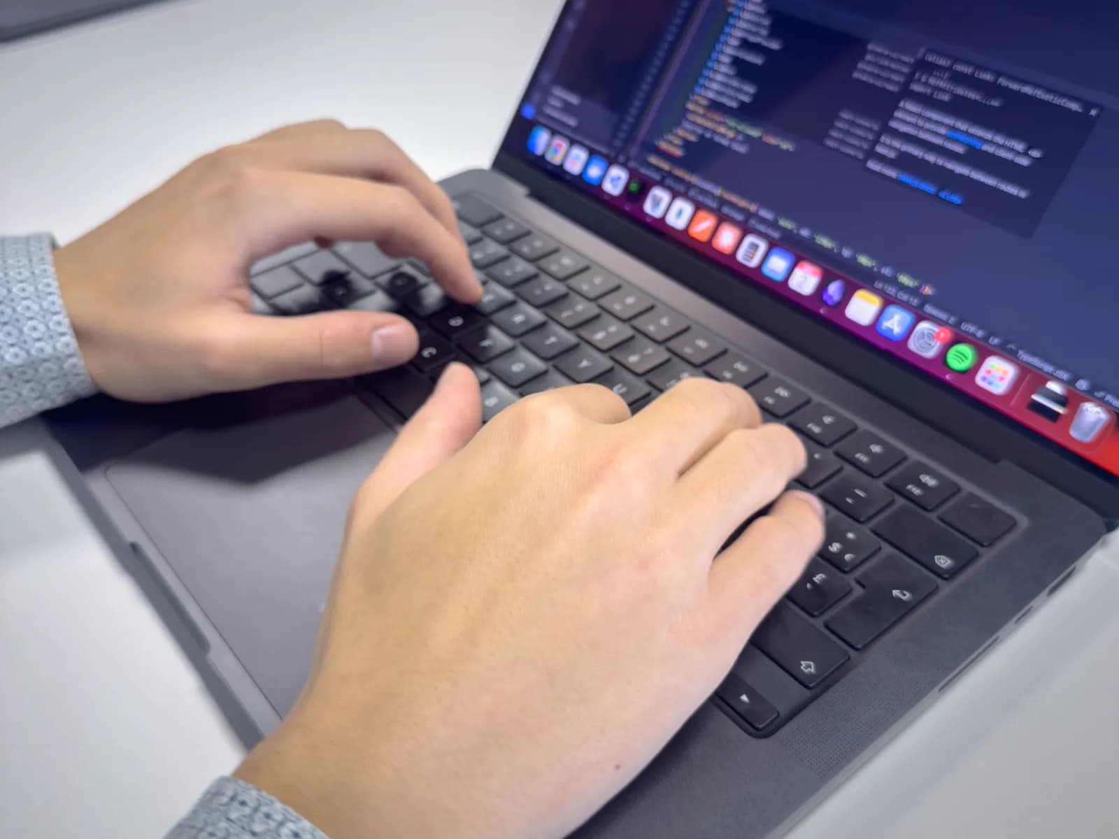 Ordinateur avec mains en train de taper du code
